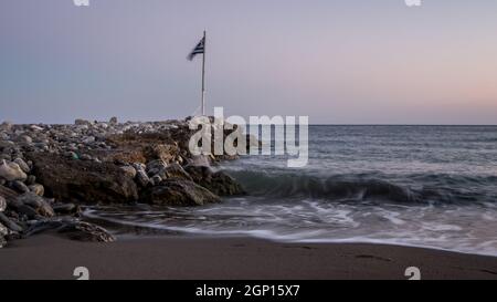 Steinerner Wellenbrecher an der Küste mit Meeresküste und Wellen in Keratokampos, Kreta Stockfoto