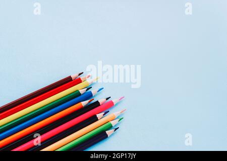 Farbstifte auf blauem Hintergrund, Draufsicht. Schulbedarf, zurück zum Schulkonzept. Flach liegend, Kopierplatz. Stockfoto