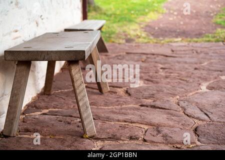 Selektiver Fokus auf der leeren Bank im Vordergrund. Wunderschöne Pennsylvania Plattenflor und Gartenpromenade mit Kopierfläche Stockfoto