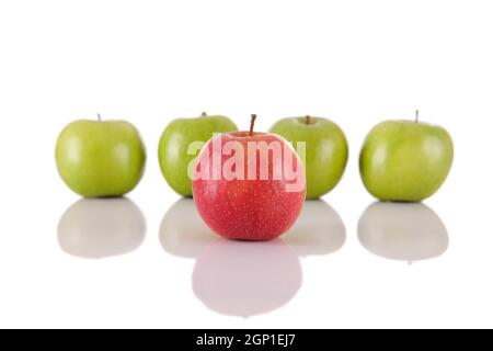 Roter Apfel unter grünen Äpfeln isoliert auf weißem Hintergrund Stockfoto