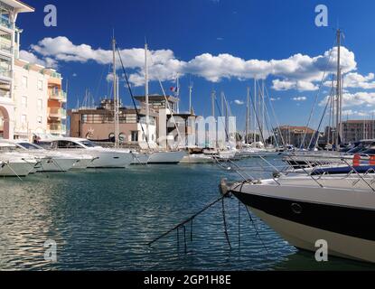 Luxuriöse Boote im Yachthafen von Frejus in Frankreich an Einem schönen Frühlingstag mit flauschigen Wolken am klaren blauen Himmel Stockfoto