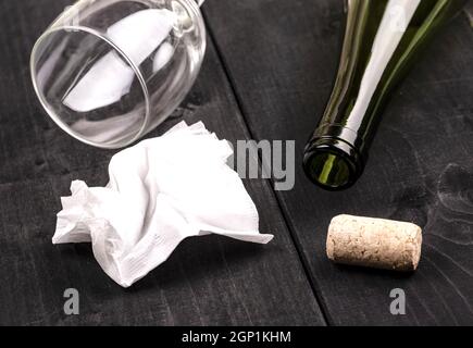Die weissen zerknittertes Papier Serviette und eine leere Weinflasche mit Kork auf alten Holztisch Stockfoto