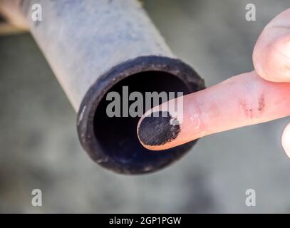 Ruß aus dem Auspuff am Finger. Prüfung des Fahrzeugs Abgasanlage des Automobilherstellers. Stockfoto