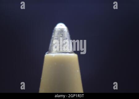 Makrofoto der Kugelschreiber-Spitze mit dunkelgrauem Hintergrund. Extremes Makrobild eines Kugelschreibers aus Metall auf grauem Hintergrund. Stockfoto