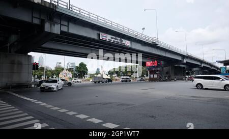 Straßenverkehr an der Kreuzung Silom Road und Rama IV Road mit Thai-Japanischer Brücke Stockfoto