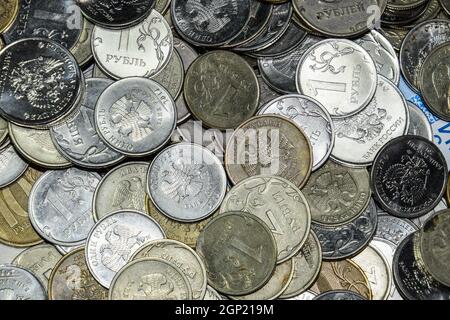 Russische Banknoten und Münzen. Eine Handvoll Münzen auf Neue Russische Banknoten im Wert von 2000 und 200 Rubel Stockfoto