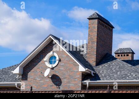 Asphalt Kies. Dekorative bitumen Schindeln auf dem Dach eines Brick House Stockfoto