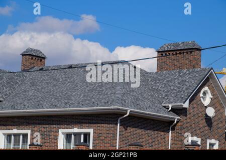 Asphalt Kies. Dekorative bitumen Schindeln auf dem Dach eines Brick House Stockfoto