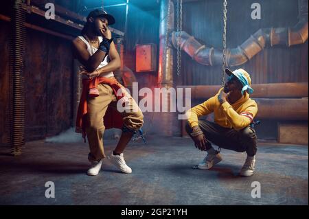 Zwei Rapper tanzen, Breakdance treten im Studio mit cooler Underground-Dekoration auf. Hip-Hop-Darsteller, trendige Rap-Sänger, Breakdancer Stockfoto