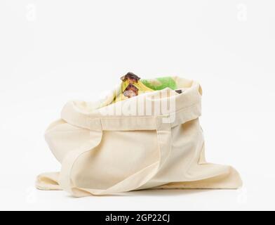 Beigefarbene Stofftasche mit frischen Früchten auf weißem Hintergrund, Null wast Stockfoto