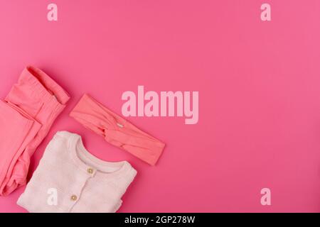 Baby Kleidung auf rosa Hintergrund Draufsicht Stockfoto