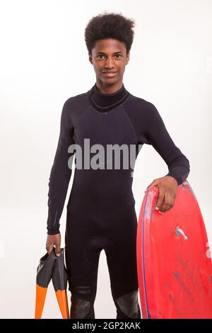 Eine junge schwarze Bodyboarder posiert im studio Stockfoto