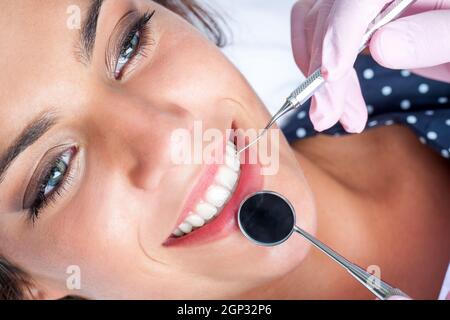 Makro Nahaufnahme von Zahnarzt Hände arbeiten attraktive weibliche Zähne. Stockfoto