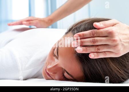 Therapeuten Hände Reiki Therapie auf Mädchen zu tun. Einer Hand am Kopf und eine hand auf Rücken. Stockfoto