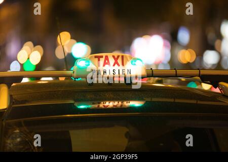 Französische Taxi mit den Champs-Elysées im Hintergrund Stockfoto