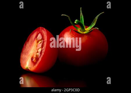 Gewaschene rote Kirschtomaten auf schwarzem Hintergrund. Nahaufnahme. Gesunde Ernährung Konzept Stockfoto