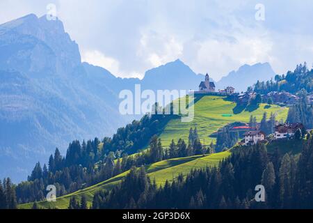 Berglandschaft mit Dörfern von Colle Santa Lucia mit Kirche in Dolomiten, Südtirol, Italien Stockfoto
