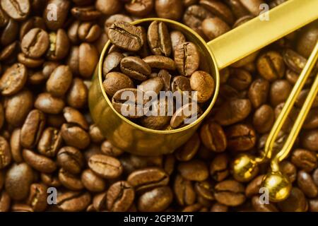 Kaffeebohnen im Messlöffel und Beutel schneiden gegen frisch gerösteten Kaffee, geringe Schärfentiefe Stockfoto