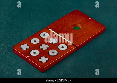 Spiel von Tic Tac Toe oder Nullen und Kreuze in Eine Holzkiste auf grünem Hintergrund Stockfoto