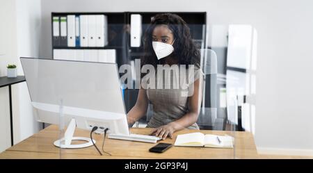 Frau Angestellte im Büro trägt FFP2 Gesichtsmaske arbeiten an Computer Stockfoto