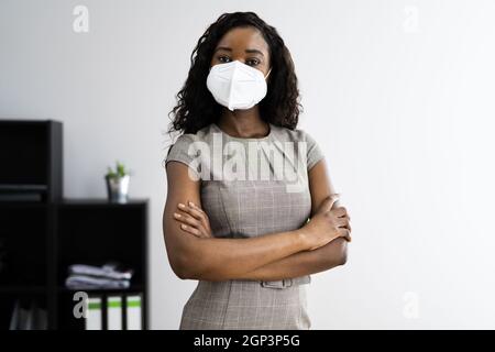 American African Frau im Büro Empfang in FFP2 Gesichtsmaske Stockfoto