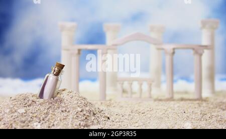 Tropischer Strand mit Ruinen im römischen Stil und Message in Bottle Stockfoto