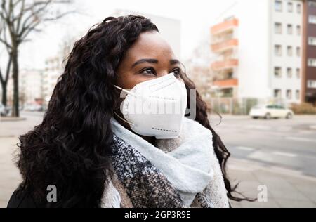 Afroamerikanische Frau trägt N95 medizinische Gesichtsmaske Stockfoto