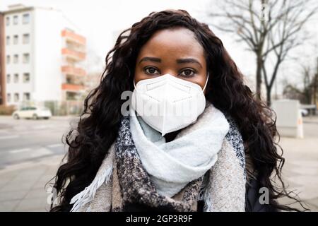 Afroamerikanische Frau trägt N95 medizinische Gesichtsmaske Stockfoto