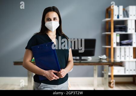 Frau an der Rezeption in FFP2 Gesichtsmaske Stockfoto