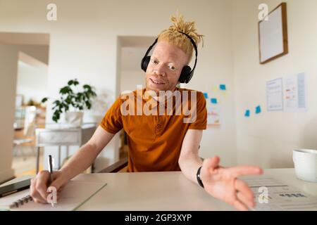 Albino-afroamerikanischer Mann, der von zu Hause aus arbeitet und Videoanruf macht Stockfoto