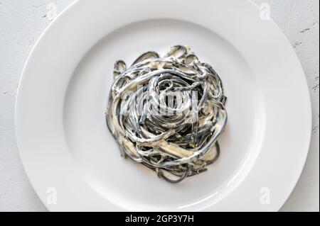 Porion von Tintenfisch Tinte Pasta mit cremiger Sauce Stockfoto