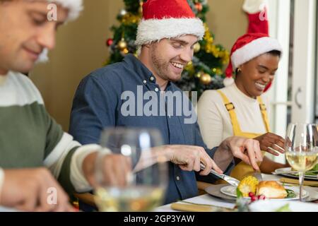 Eine Gruppe glücklicher, vielfältiger weiblicher und männlicher Freunde, die zu Hause Weihnachten feiern Stockfoto