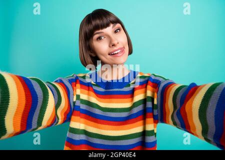 Foto Porträt lächelnd bob haarige Frau in legerer Kleidung Aufnahme Selfie zeigt Zunge isoliert hell blaugrün Hintergrund Stockfoto