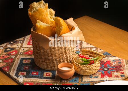 Frisches georgisches Gebäck – Brot und Pitabrot in einem Korb. Hausgemachtes nationales georgisches Gericht. Konzept: Speisekarte für ein Restaurant Stockfoto