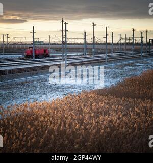 Rote Lokomotive im Winter auf einer Strecke mit Dieselkraftstoff Stockfoto