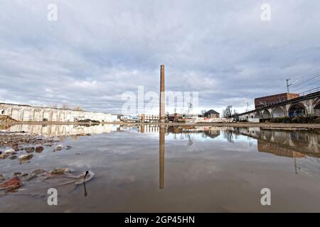 Industriebrache mit einsamen Schornstein in einer Pfütze reflektiert köln Stockfoto