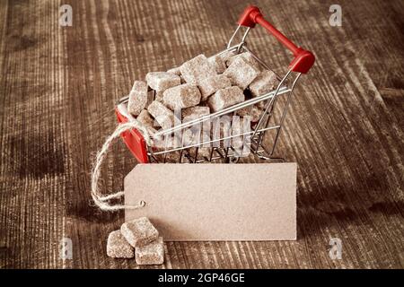 Würfelzucker in Warenkorb mit leerem Papier-tag Stockfoto