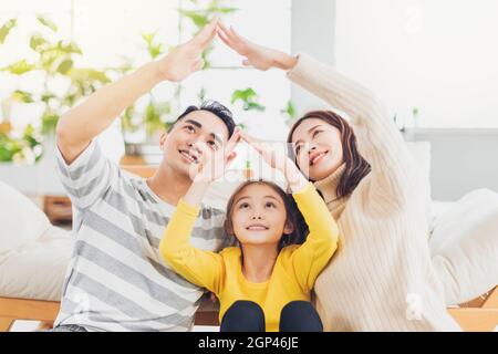 Glücklich asiatische Familie bilden Hausdach mit ihren Händen an Zu Hause Stockfoto