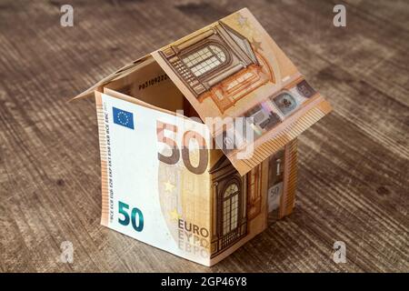 Haus aus fünfzig Euro-Banknoten auf einem hölzernen Hintergrund Stockfoto