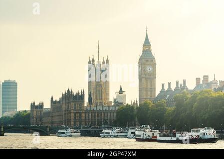 Der Palast von Westminster und der Uhrturm mit Booten auf der Themse in London, England, Großbritannien Stockfoto