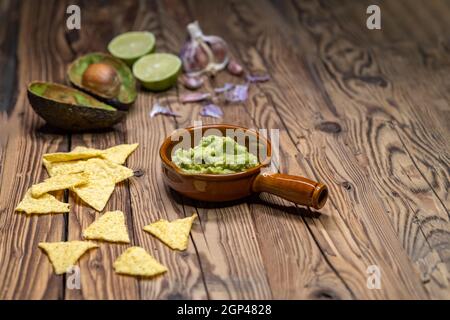 Avocado Dip mit Knoblauch, Chili, Pfeffer und Limettensaft mit Mais Nachos gewürzt Stockfoto