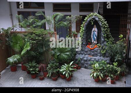 Der Innenhof mit einer Statue unserer Lieben Frau von Lourdes im Mutterhaus von Mutter Teresa in Kalkutta, Westbengalen, Indien Stockfoto