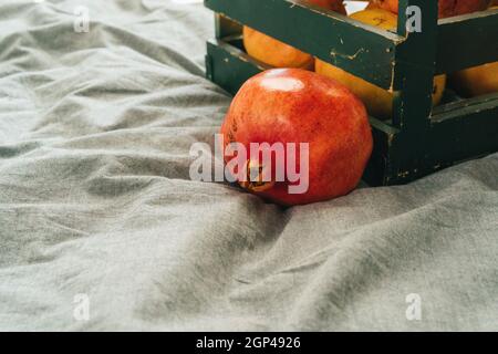 Frische Granatäpfel in einer alten Kiste auf Holzhintergrund Stockfoto