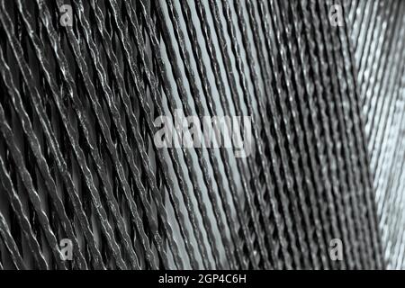 Architektonisches Metallpaneel für dekorative Gebäudewand. Schwarz und Silber Metall Dekoration Material. Verdrehter Eisendraht Panel abstrakten Hintergrund. Rau Stockfoto