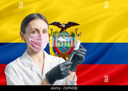 Ärztin bereitet die Impfung vor dem Hintergrund der Flagge Ecuadors vor. Impfkonzept Ecuador. Stockfoto