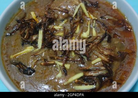 Nahaufnahme des traditionellen pakistanischen Haleem-Gerichts mit Salat und Zitronensaft. Stockfoto