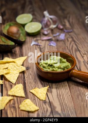 Avocado Dip mit Knoblauch, Chili, Pfeffer und Limettensaft mit Mais Nachos gewürzt Stockfoto