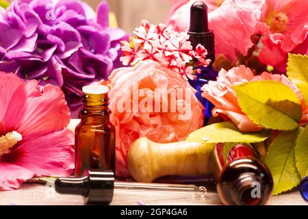 Blumen und Flaschen mit ätherischen Ölen für die Aromatherapie Stockfoto