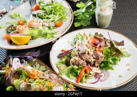 Fleischvorspeise aus Kalbfleisch, Sauce und Gemüse. Grüner Salat zum Dekorieren des Gerichts. Stockfoto