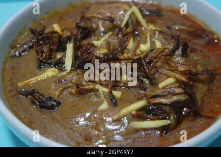 Nahaufnahme des traditionellen pakistanischen Haleem-Gerichts mit Salat und Zitronensaft. Stockfoto